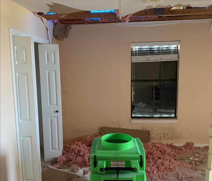 a caved in ceiling with insulation on the floor