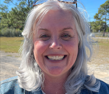 Smiling female with shoulder length silver hair